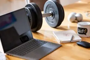 Die Kraft der Worte - symbolisiert durch einen Laptop, ein Notizbuch und eine Hantel